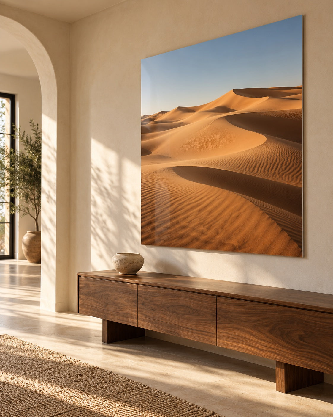 A sand dune metal print above a walnut console in a sunlit hallway
