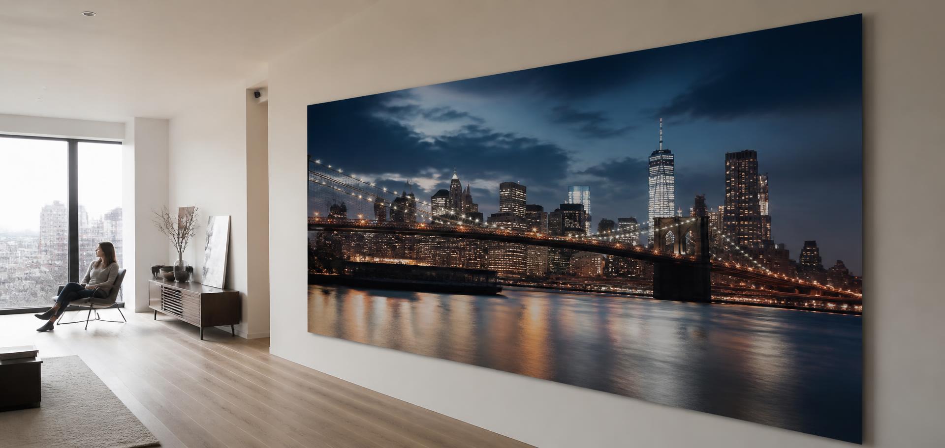 A very large metal print of a blue-hour cityscape on a long wall in a modern apartment