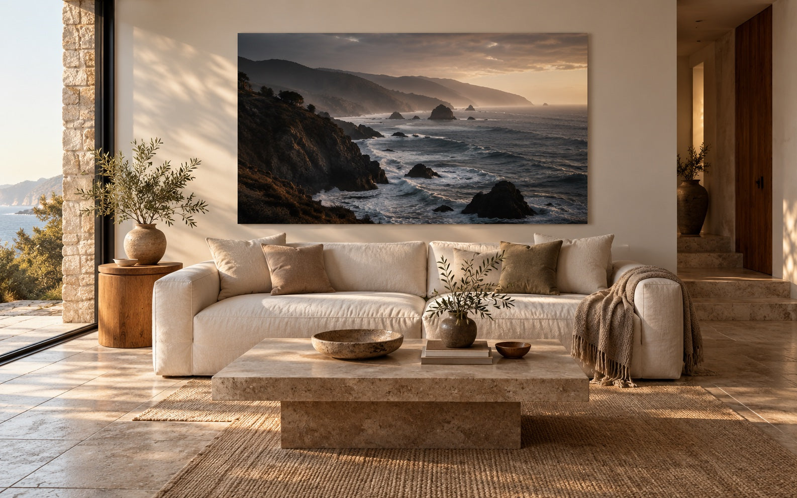 A coastal metal print above a linen sofa in a sunlit living room